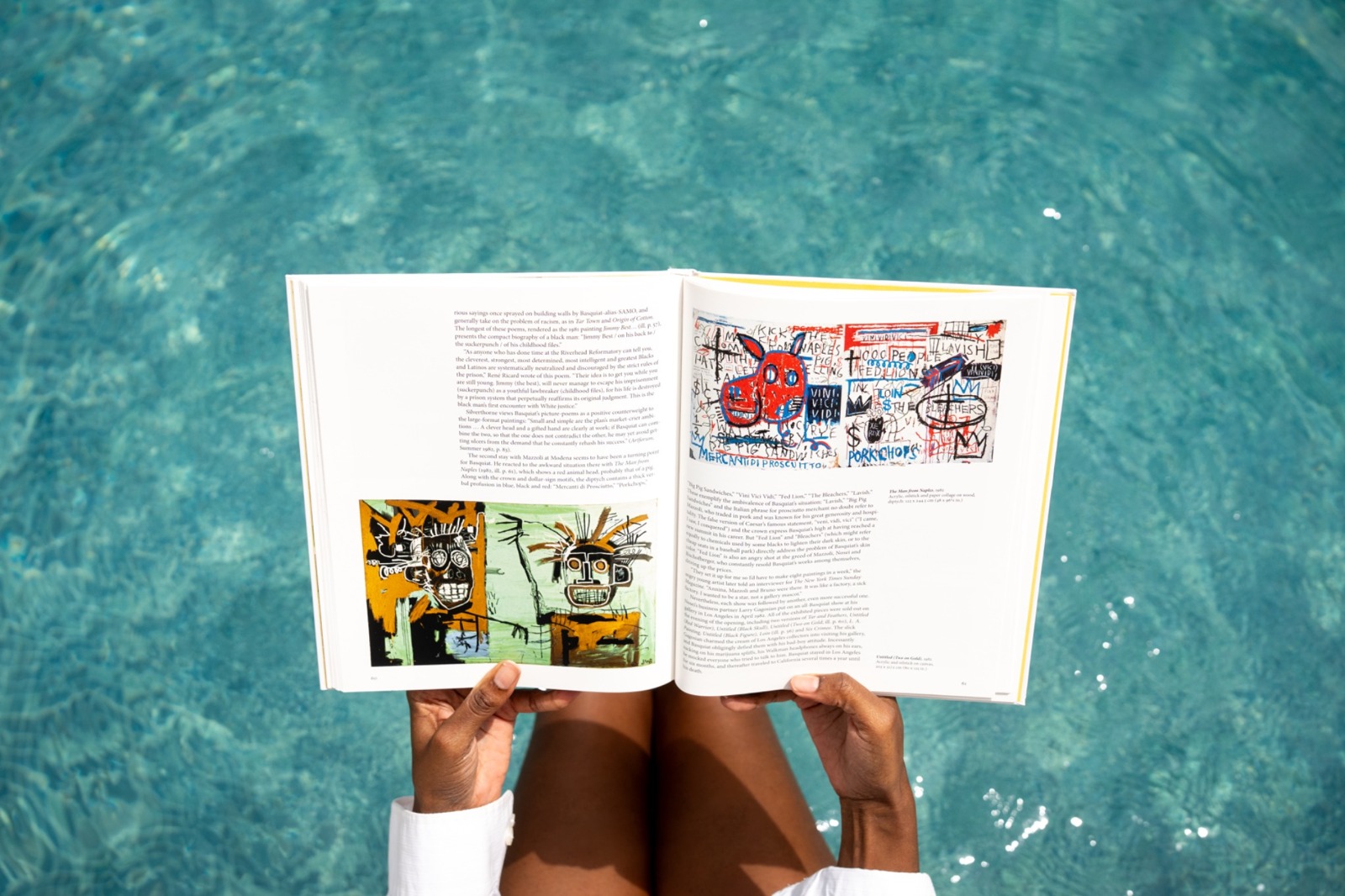 Guest reading a Jean-Michel Basquiat book beside the turquoise pool